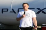 Elon Musk speaking in front of a SpaceX rocket