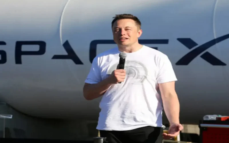 Elon Musk speaking in front of a SpaceX rocket