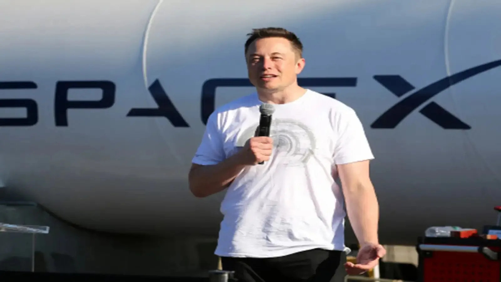 Elon Musk speaking in front of a SpaceX rocket