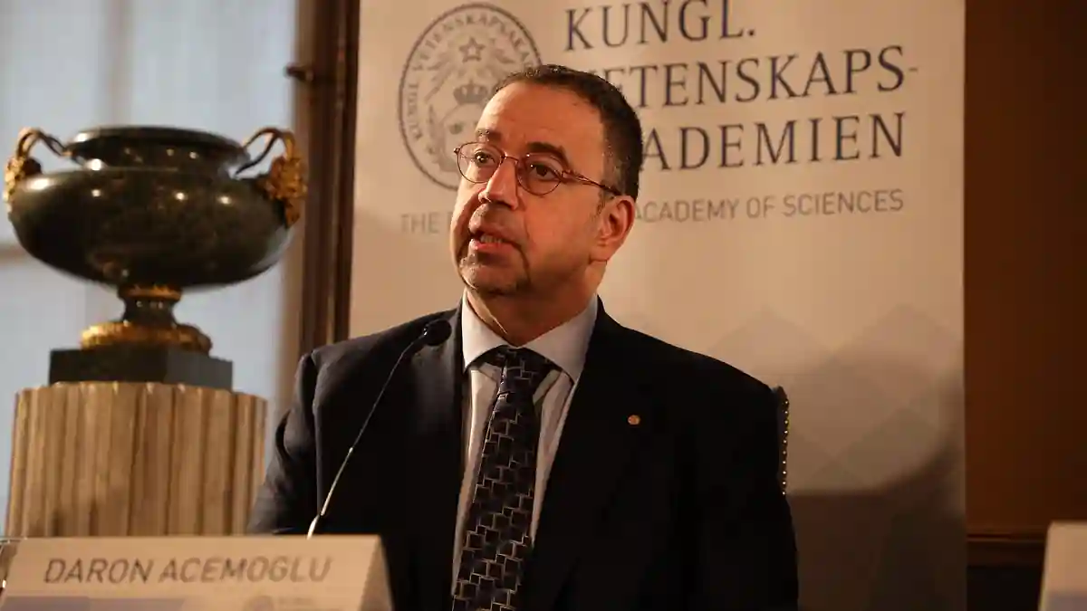 Economist Daron Acemoglu speaking at a Royal Swedish Academy of Sciences press conference behind a name plate